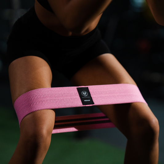 Fitnessoefening met weerstandsband voor het versterken van spieren en verbeteren van flexibiliteit.