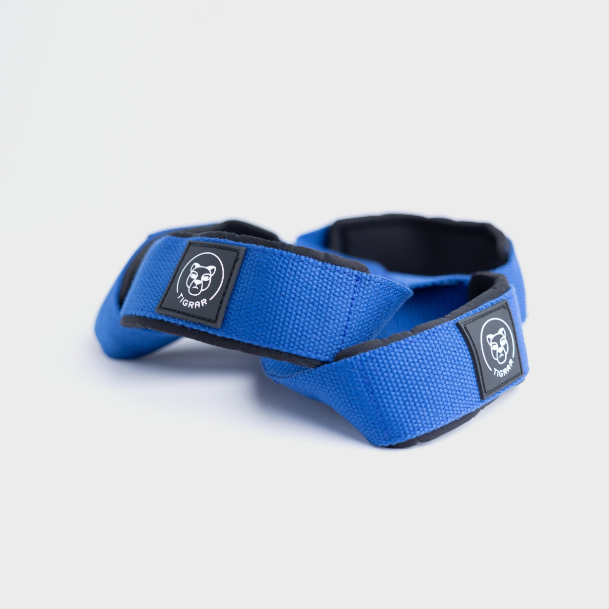 Tigrar's blauwe Figure 8 straps, duurzaam en klaar voor zware trainingen, gepresenteerd op een grijze achtergrond.