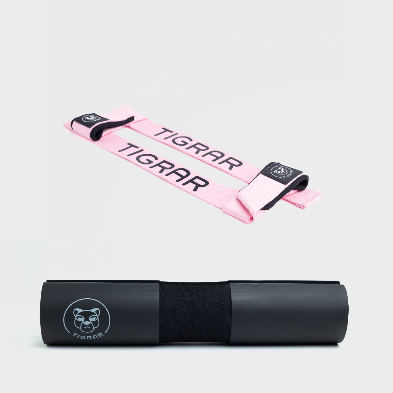 Set van roze lifting straps en zwarte Tigrar barbell pad, voor anti-slip grip en bescherming tijdens intensieve workouts.