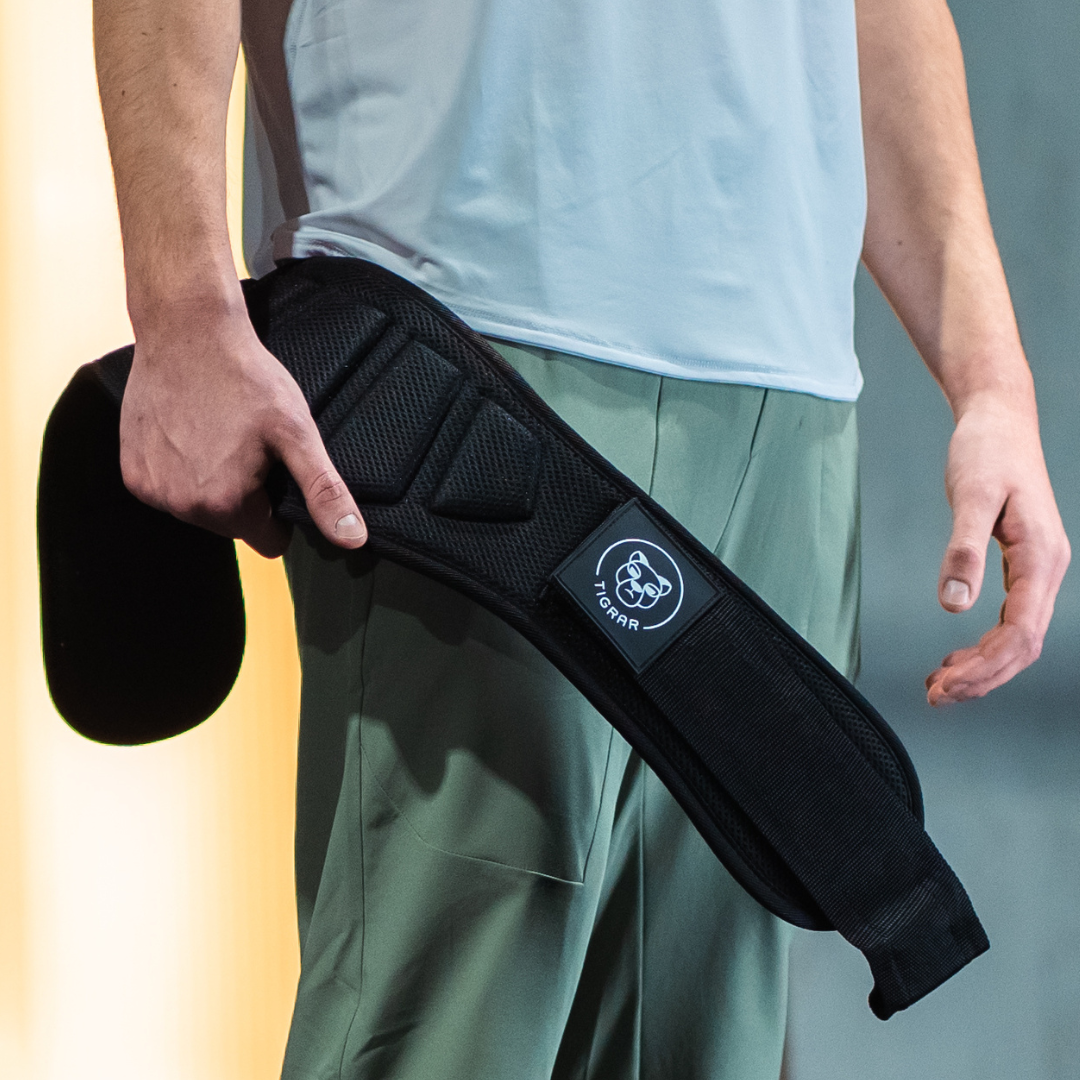 Man toont Tigrar lifting belt, cruciaal voor deadlift, onderdeel van Elite Powerhouse Pack.