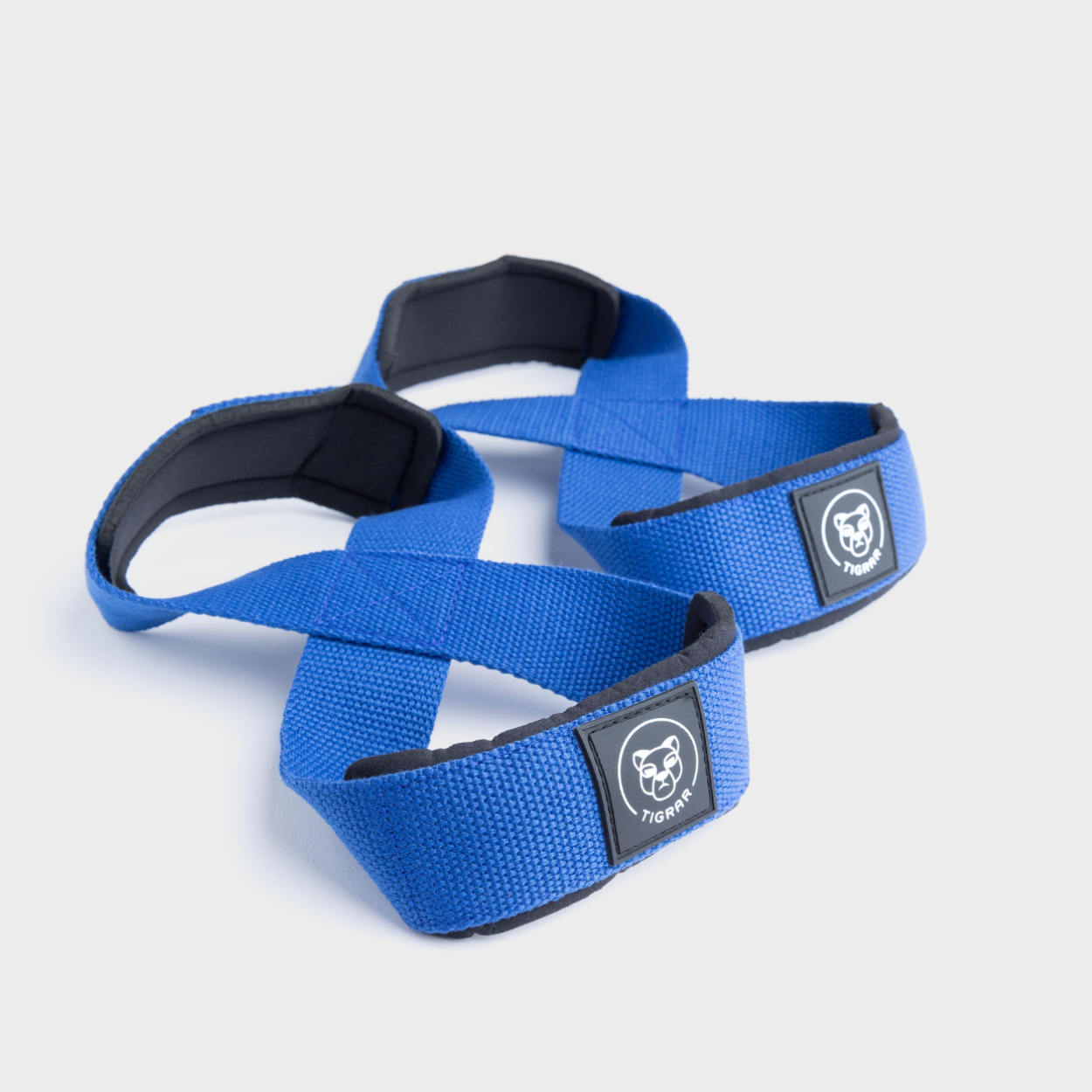Duurzame en stijlvolle blauwe Tigrar lifting straps in Figure 8 ontwerp, voor een grijze achtergrond.