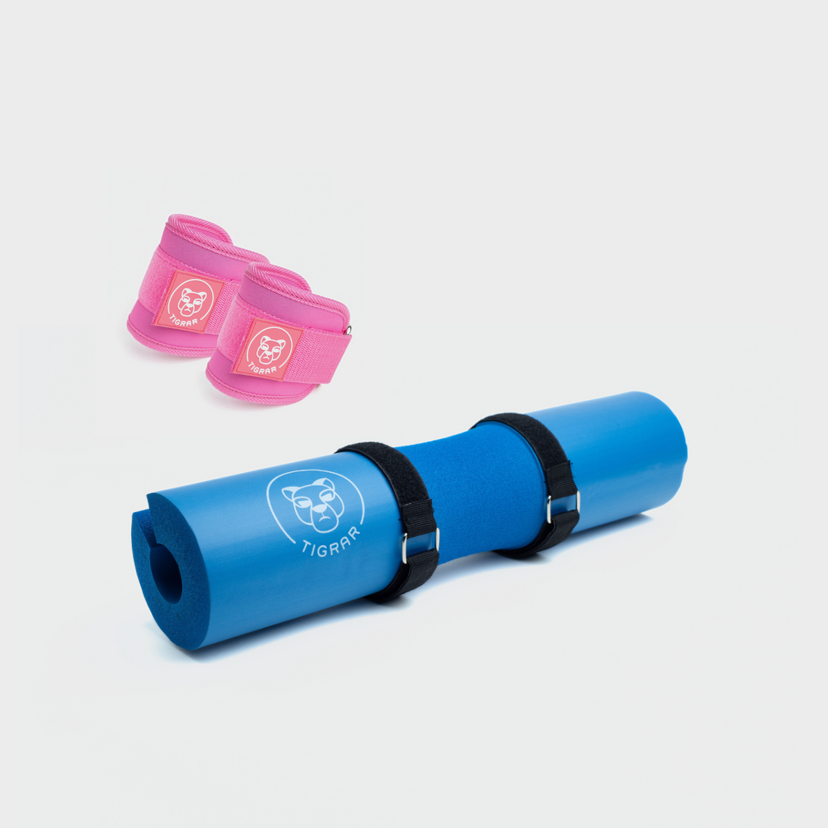 Blauwe Tigrar hip thrust pad en roze enkel straps voor hip thrusts en krachttraining.