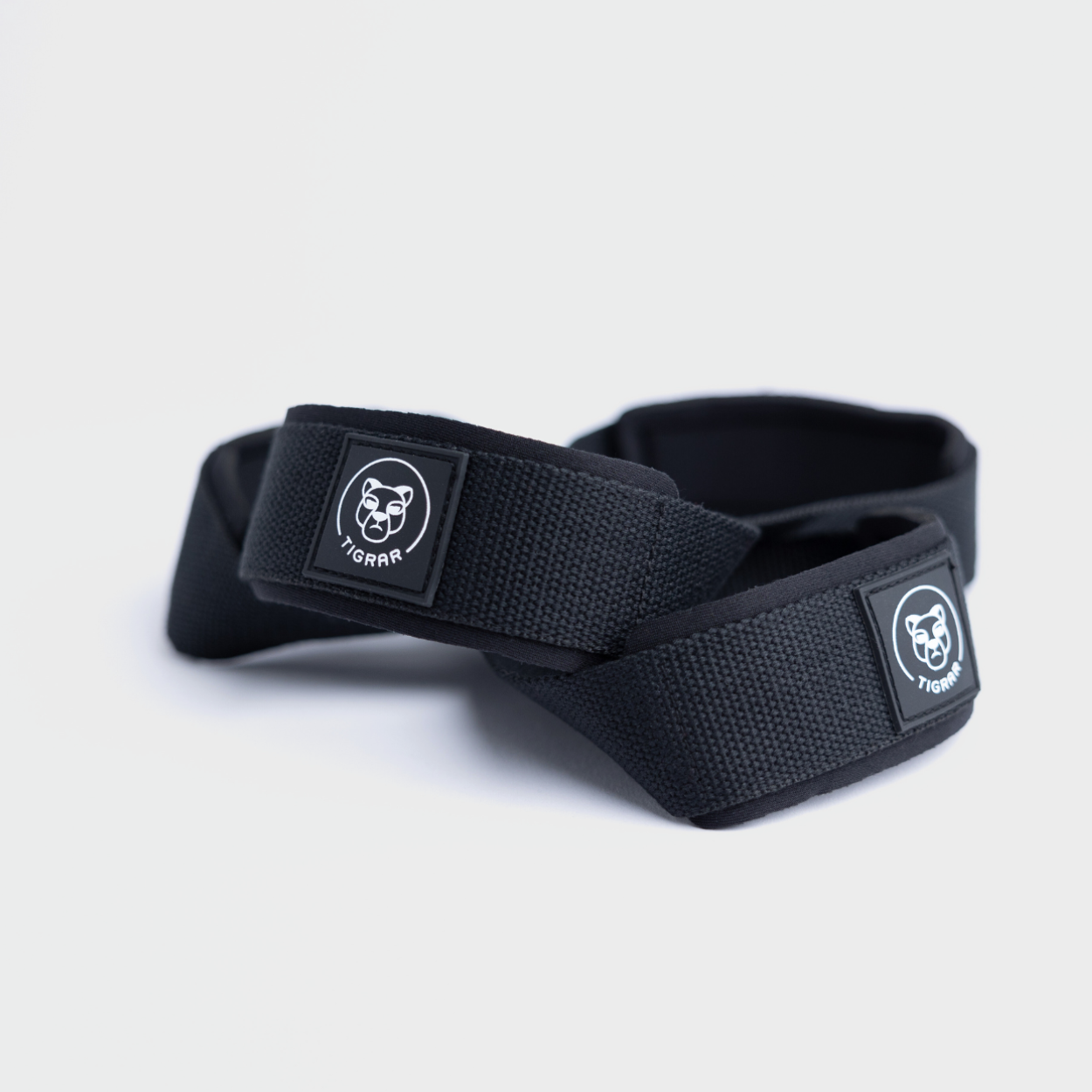 Zwart nylon Tigrar Figure 8 lifting straps, essentieel voor krachttraining, voor een grijze achtergrond.