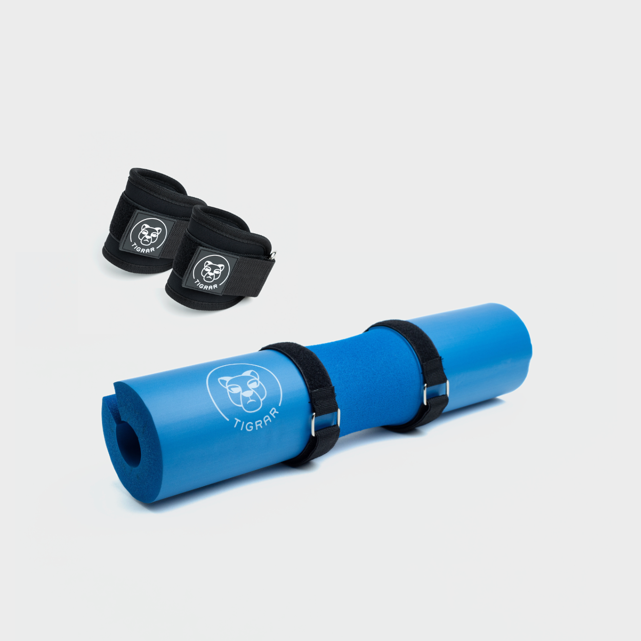 Blauwe Tigrar hip thrust foam pad en zwarte enkel straps voor beenoefeningen en hip thrusts.
