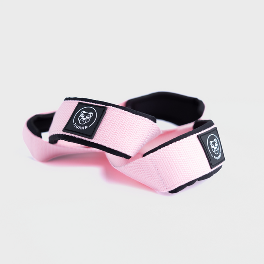 Tigrar lifting straps in opvallend roze met extra neopreen padding, gepresenteerd op een grijze achtergrond.