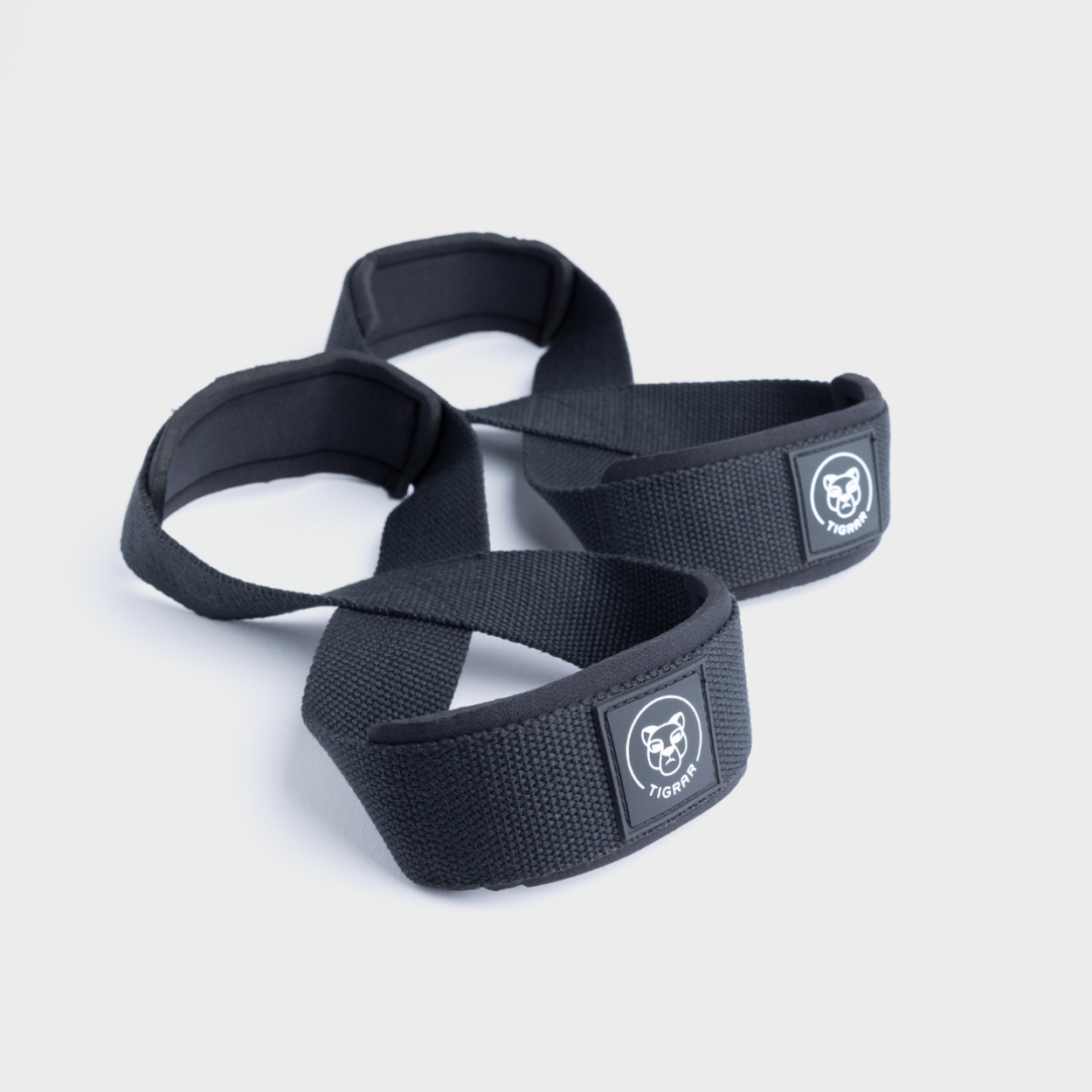 Tigrar Figure 8 straps van zwart nylon, perfect voor gewichtheffen, met grijze achtergrond.