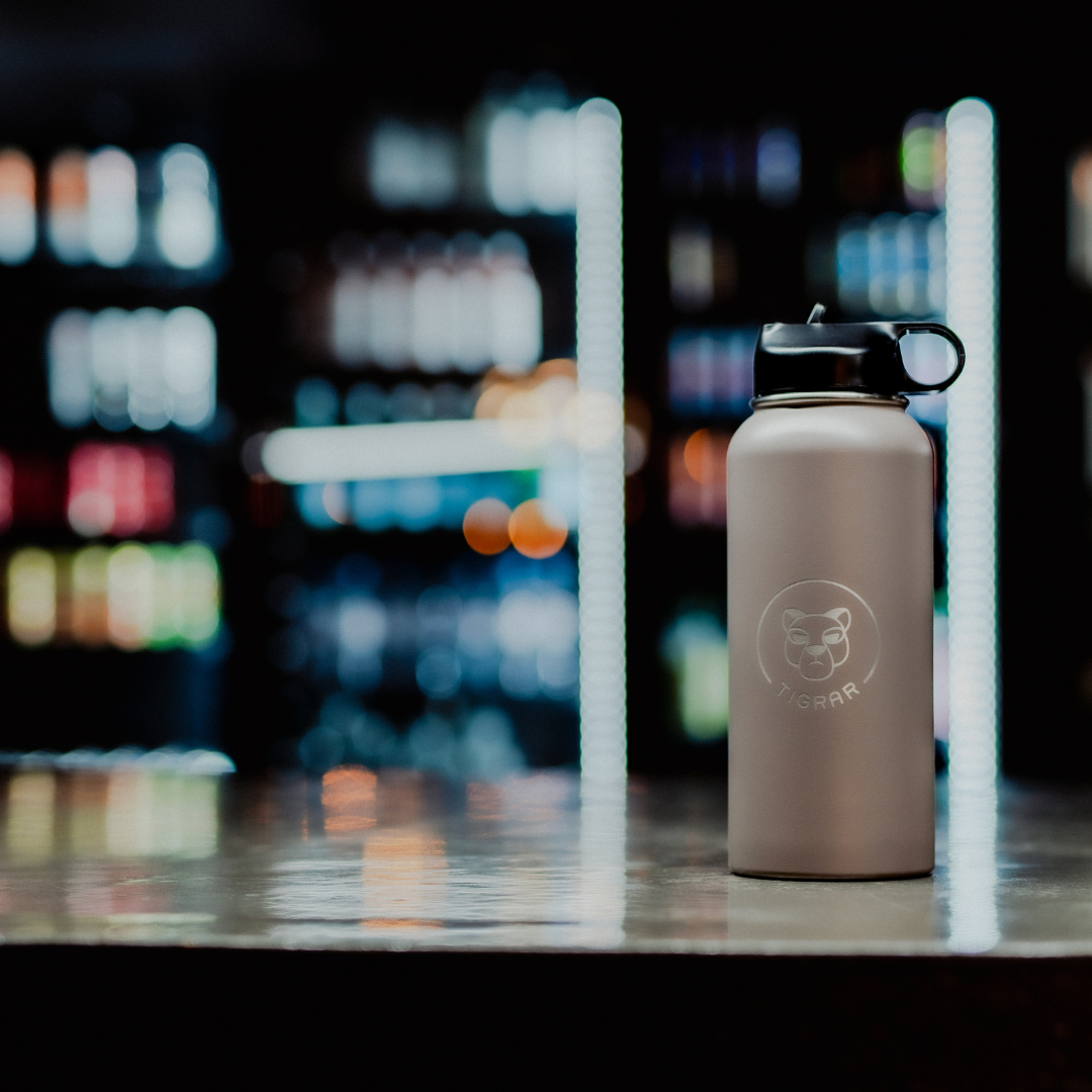 Tigrar thermosfles, centraal op de sportschoolbar, accentueert het belang van vochtinname voor en na de workout.