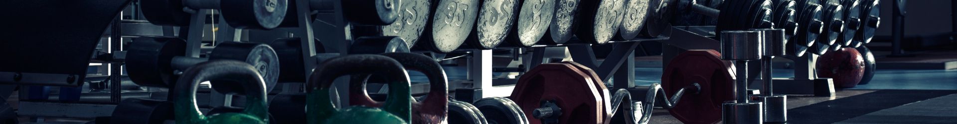 Sportschool met een dumbbell rek en kettlebells in het zicht.