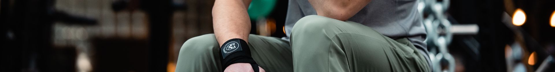 Man in de gym bereidt zich voor op een bench press en gebruikt daarbij wrist wraps.