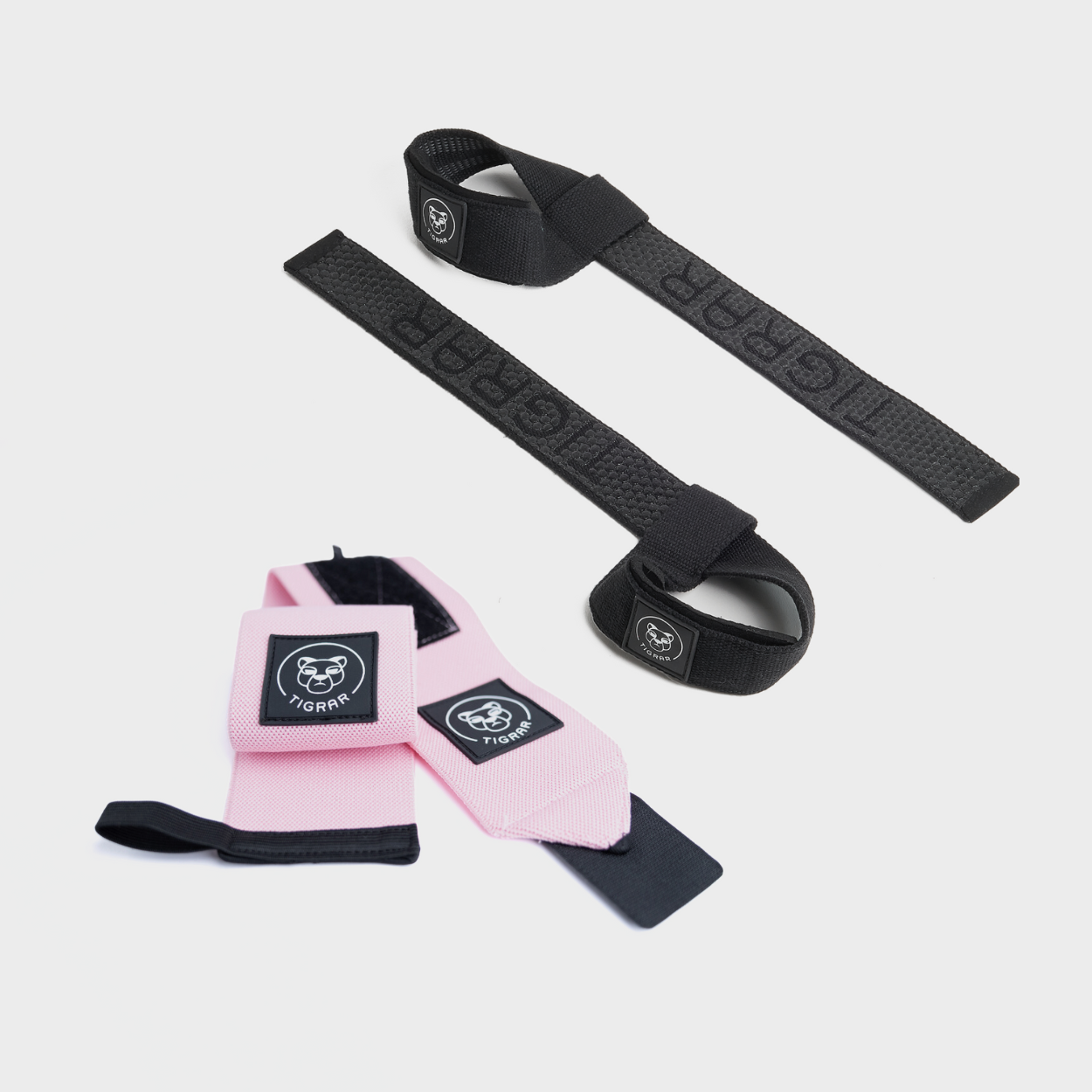 Tigrar fitnessbundel met roze wrist straps en zwarte weightlifting straps voor betere grip en polsbescherming.