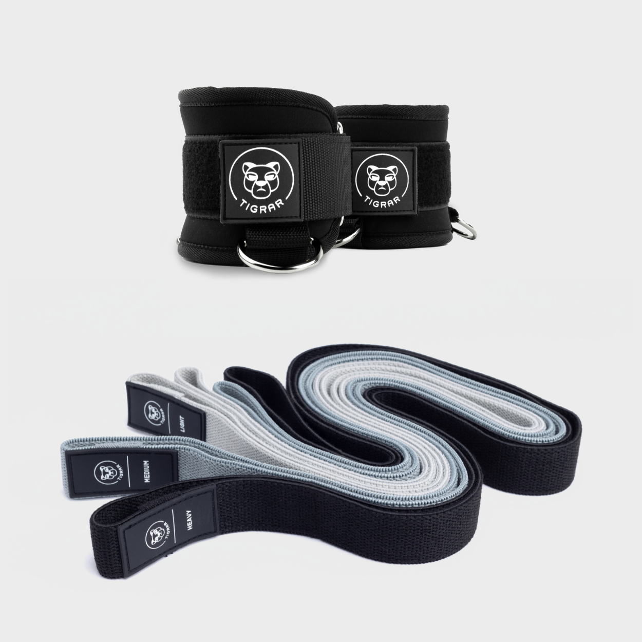 Complete Tigrar functional training set met drie verschillende gekleurde elastiek banden en zwarte gym ankle straps met zachte padding en bevestigingsringen.