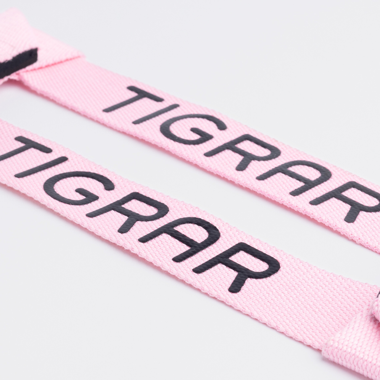 Close-up van roze Tigrar lifting straps, ontworpen voor een stevige grip en comfort tijdens trainingssessies.