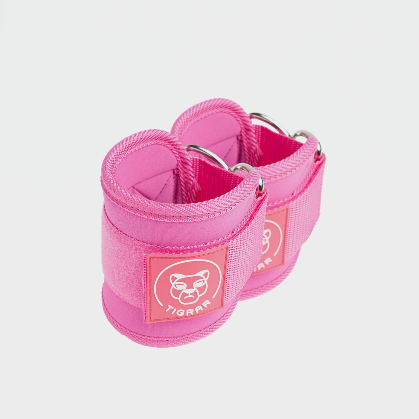 Tigrar enkel straps in roze, zacht gevoerd en stevig bevestigd om de enkel tijdens kabeloefeningen.
