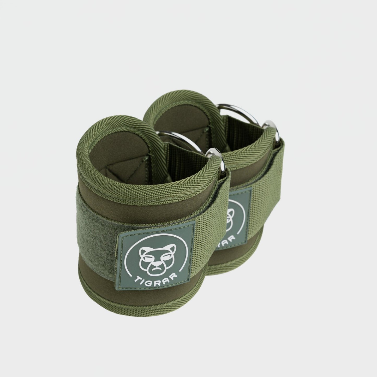 Groene Tigrar ankle strap met metalen bevestiging, klaar voor intensieve leg raises met kabelmachine.