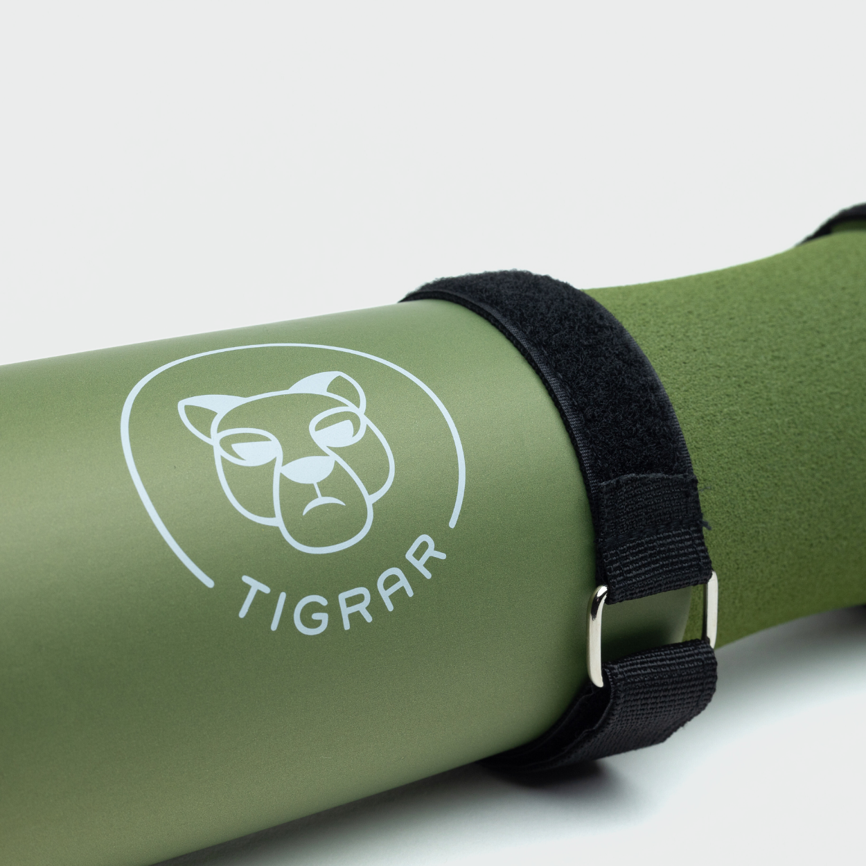 Close-up van een groene Tigrar gym barbell pad met klittenband strap, op een grijze achtergrond.