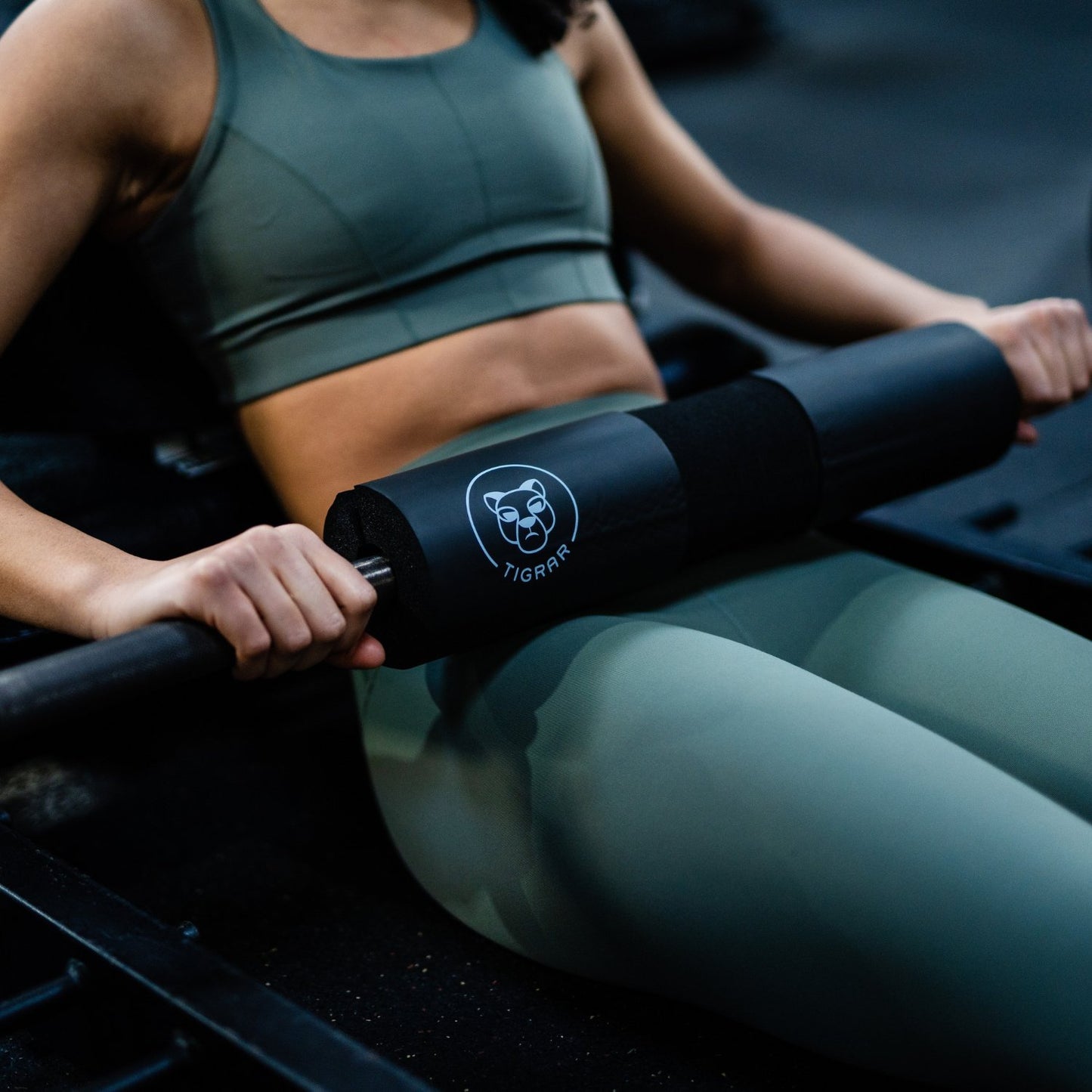 Close-up van een vrouw die een hip thrust doet met een barbell hip thrust pad op haar heupen