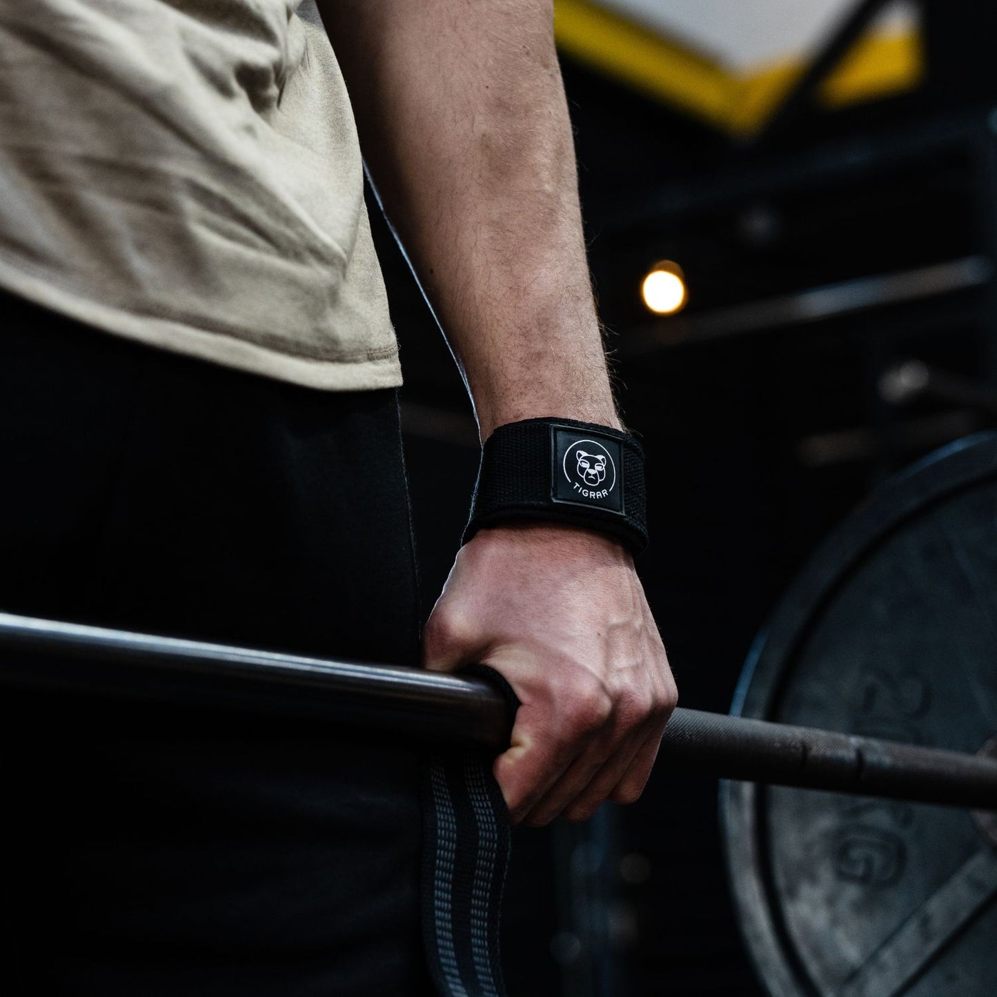 Close-up van atleet's hand die een zwarte Tigrar lifting strap om heeft tijdens een deadlift, benadrukt gripstabiliteit.