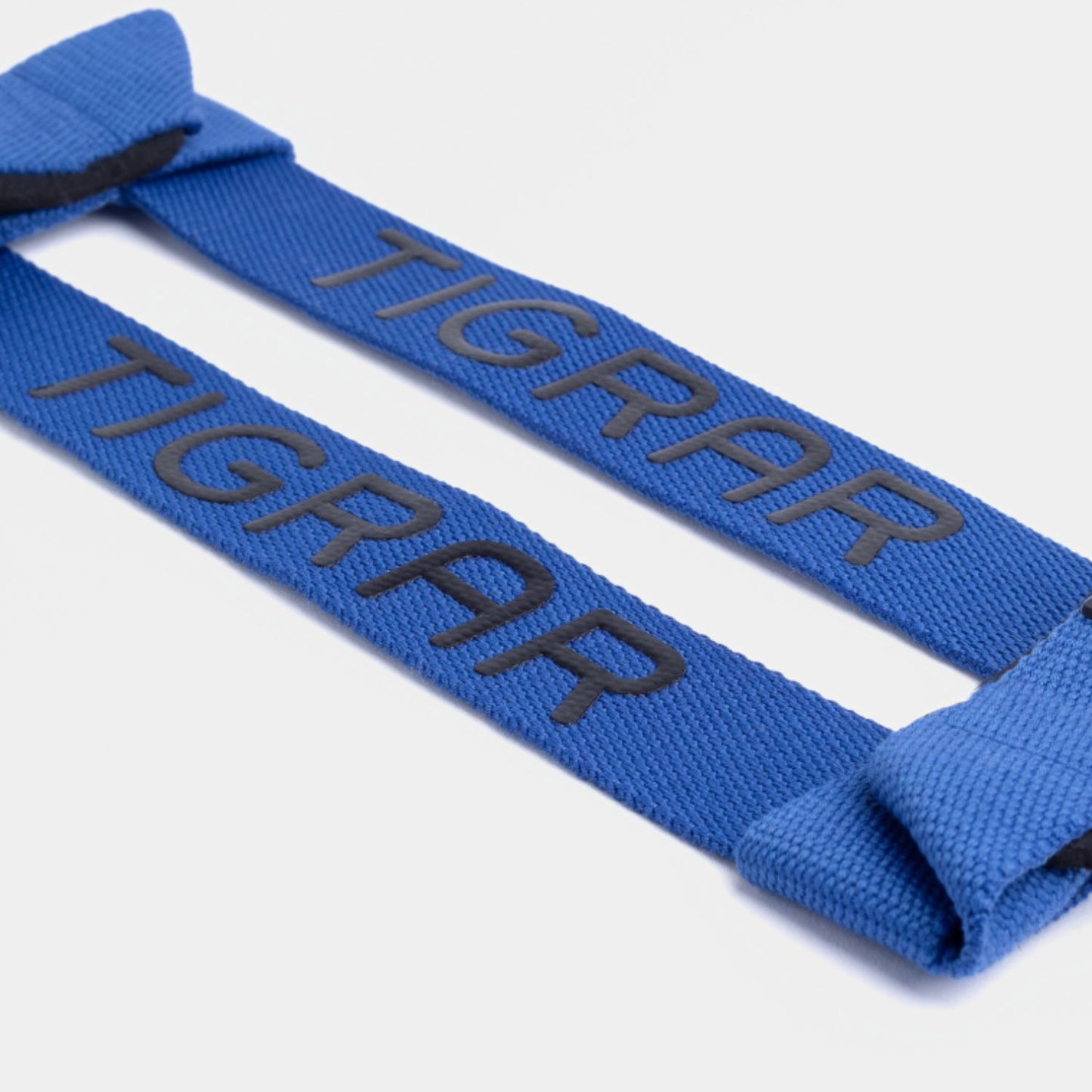 Tigrar lifting strap close-up, onthult robuuste nylon materiaal, zachte padding, en blauwe kleur.