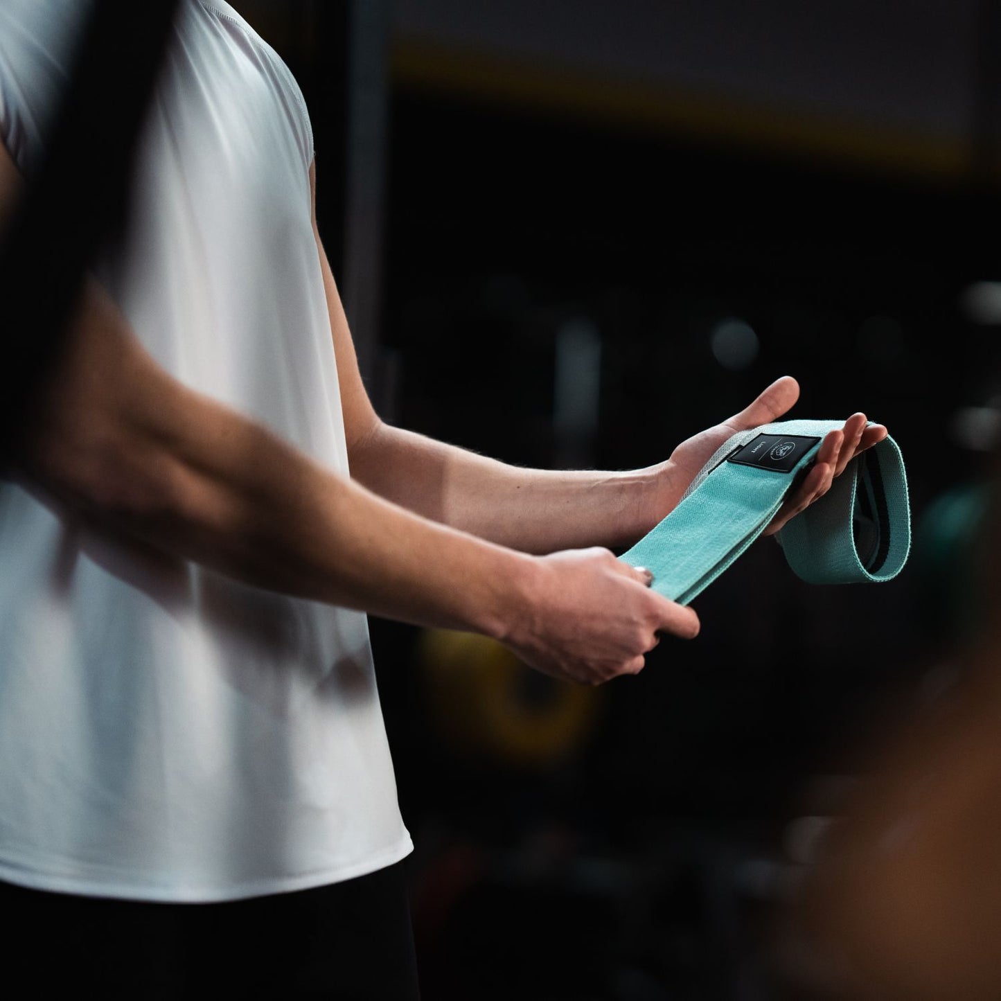 Atleet in de gym met een booty resistance bands set van Tigrar in zijn hand.