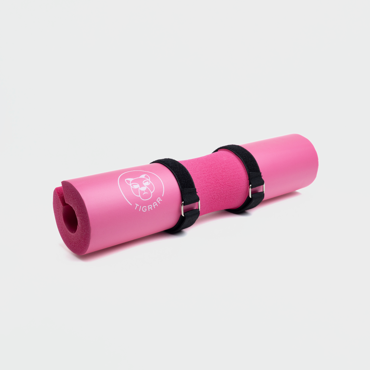 Tigrar roze barbell pad met klittenband straps, gepresenteerd tegen een rustige grijze achtergrond.