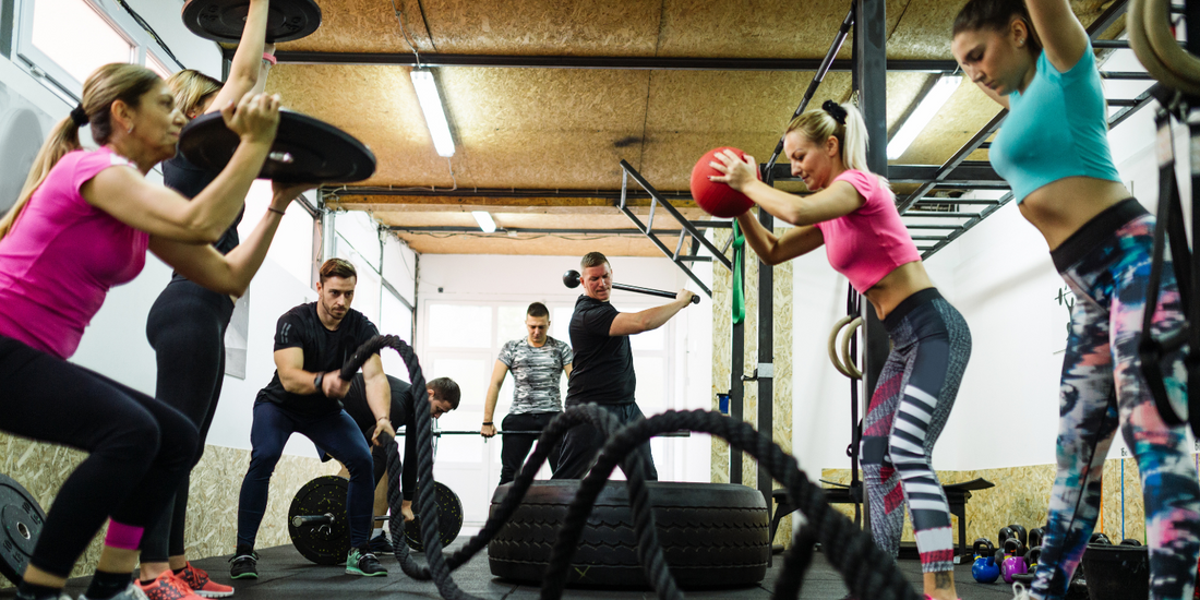 Groep van 8 personen doen een circuittraining in de gym