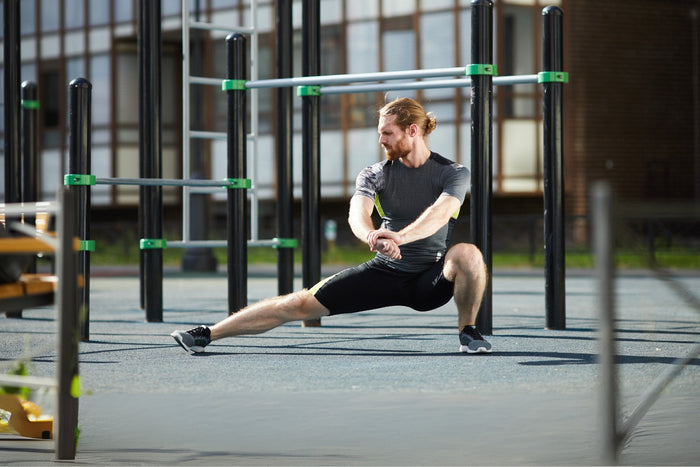 Man doet een adductor oefening buiten