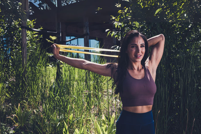 Band pull apart uitgevoerd door een sportieve vrouw