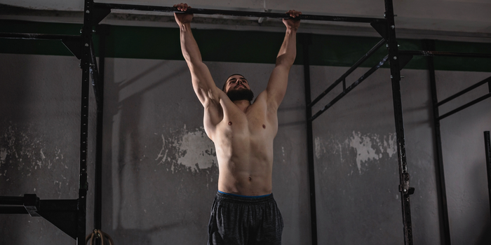 Man voert een Dead hang oefening uit voor sterke onderarmen en polsen