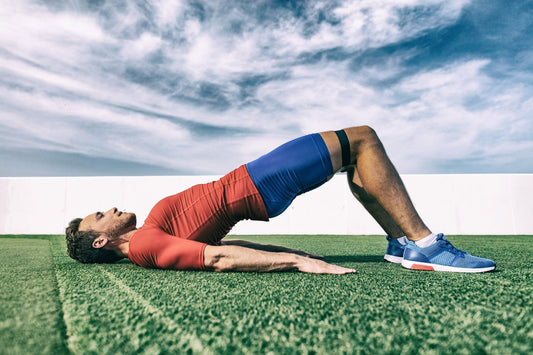 banded glute bridge buiten uitgevoerd door een jonge sportman