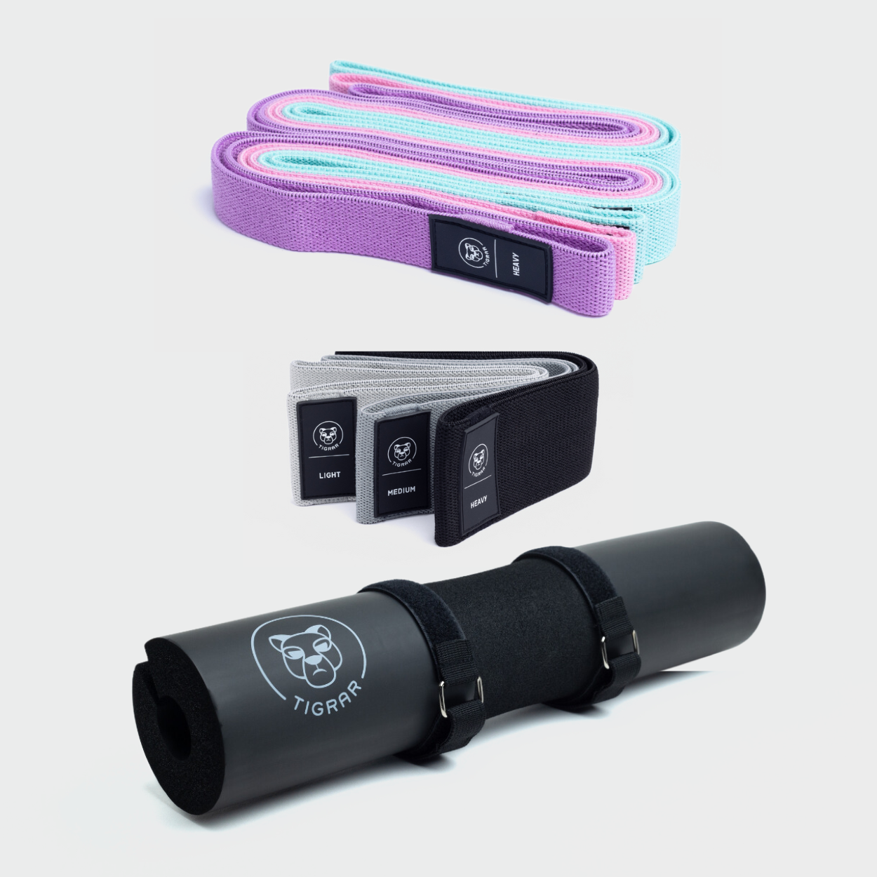 Lichte kleuren lange Tigrar elastiek banden, donker gekleurde korte banden en een zwarte squat pad getoond met een grijze achtergrond