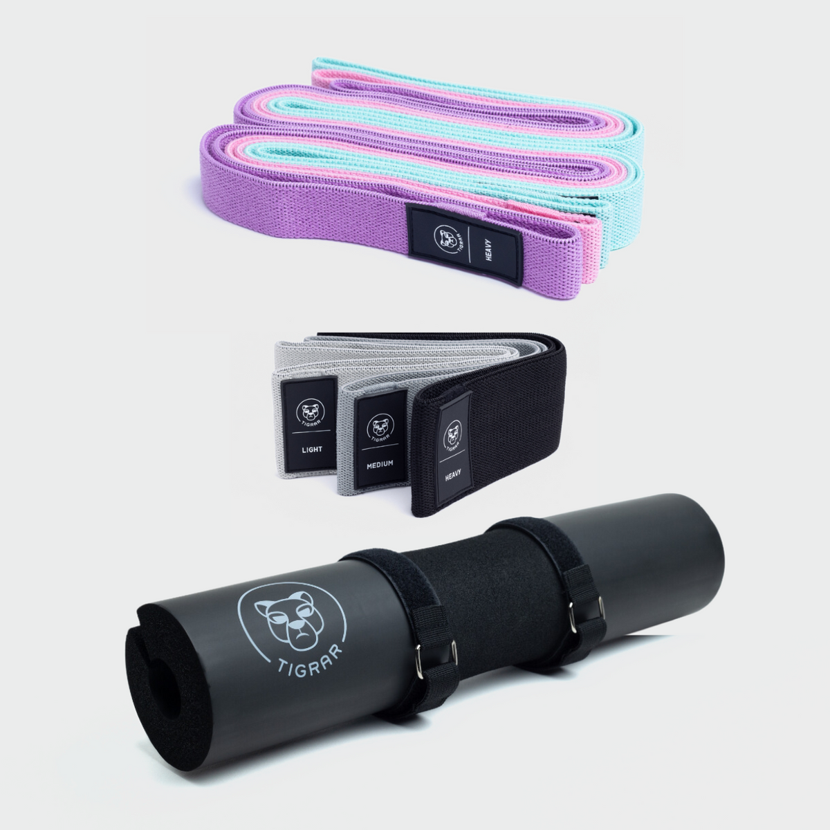 Lichte kleuren lange Tigrar elastiek banden, donker gekleurde korte banden en een zwarte squat pad getoond met een grijze achtergrond