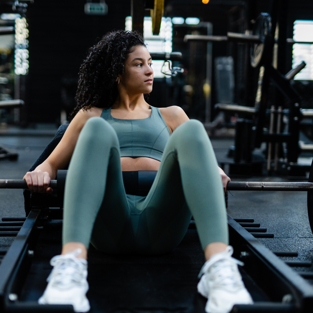 Sporter voert een hip thrust uit met een comfortabele gym barbell pad om de barbell.
