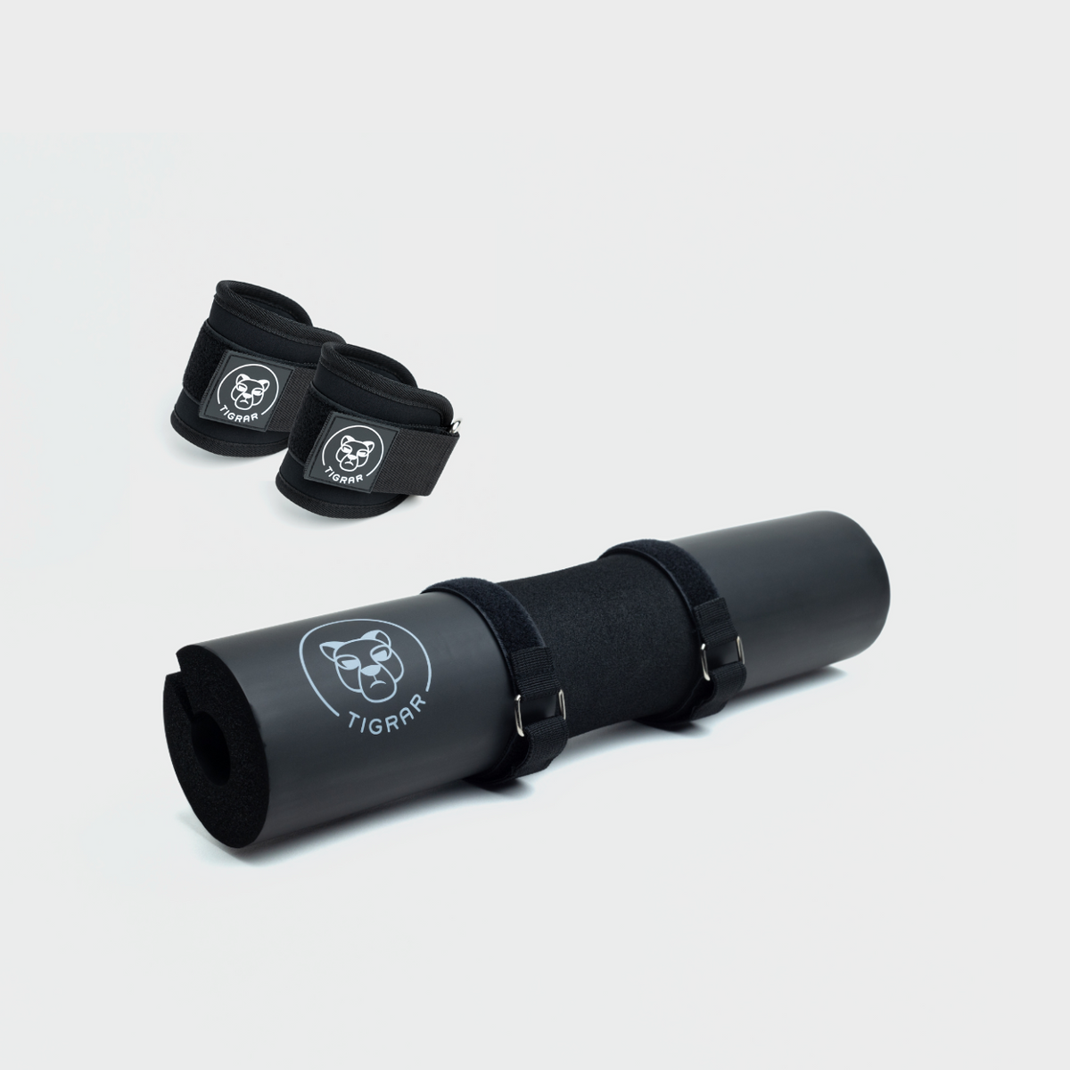Zwarte hip thrust foam pad en zwarte enkel straps voor gewichtheffen en beenoefeningen.