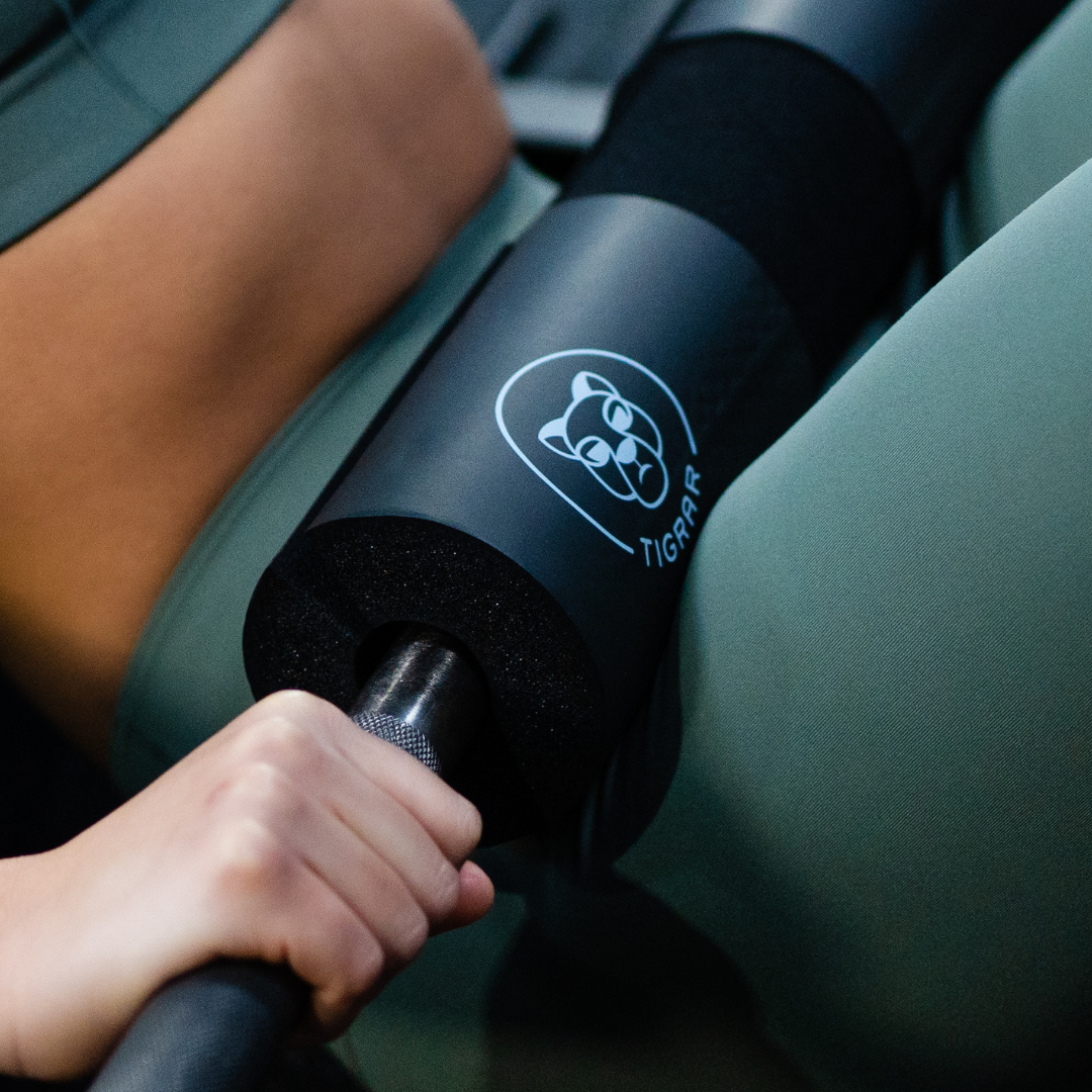 Atlete voert krachtige workout uit waarbij de Tigrar barbell pad wordt gebruikt. Oefening gericht op bilspieren.