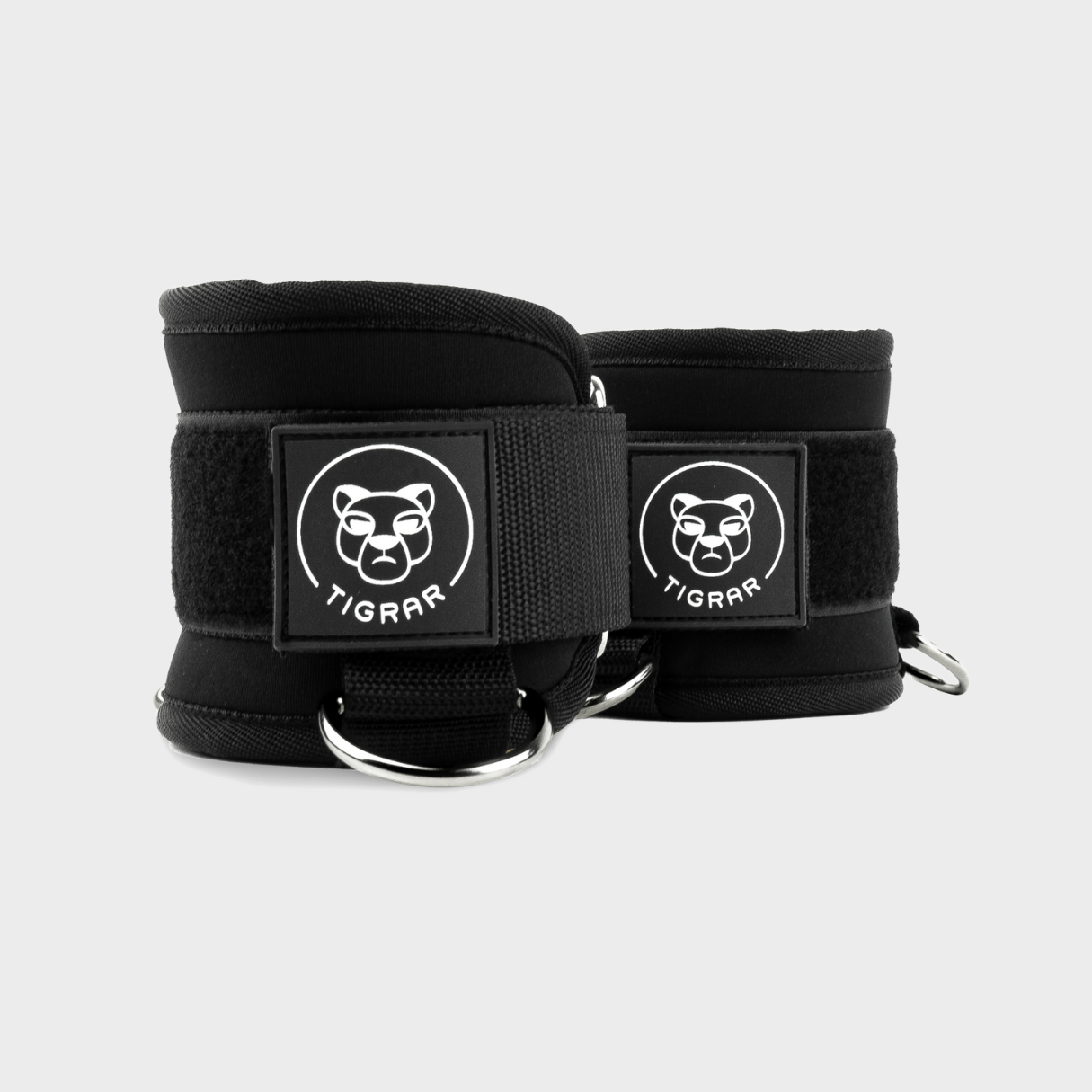 Zwarte Tigrar ankle straps met zachte neopreen padding en slijtvaste nylon, tegen een lichtgrijze achtergrond voor duidelijke weergave.