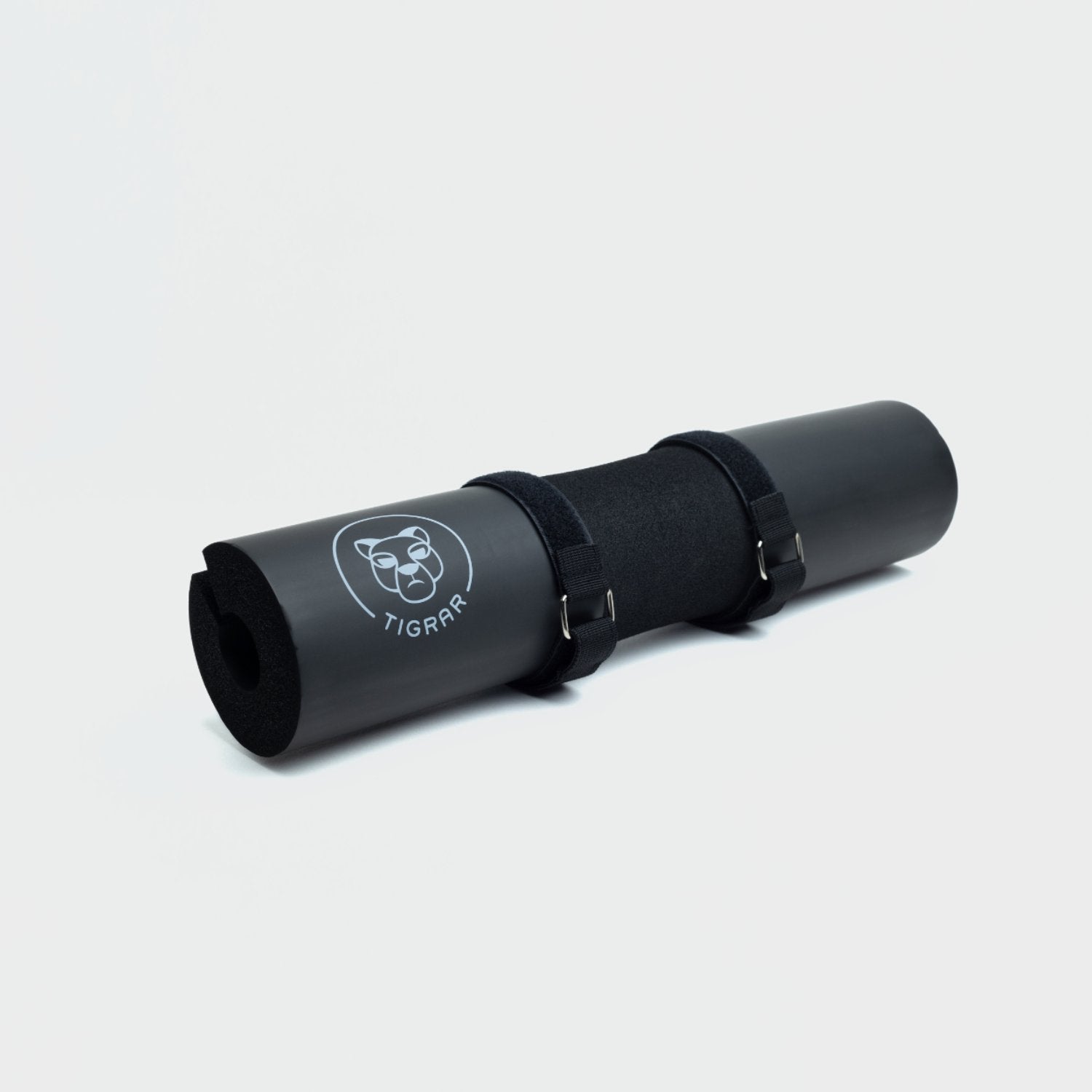 Zwarte Tigrar barbell pad voor hip thrusts, bevestigd met klittenband, tegen grijze achtergrond